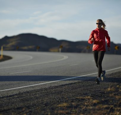 Woman running on big road, mountains in background