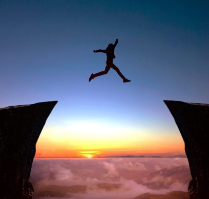 Person jumping from one cliff to another